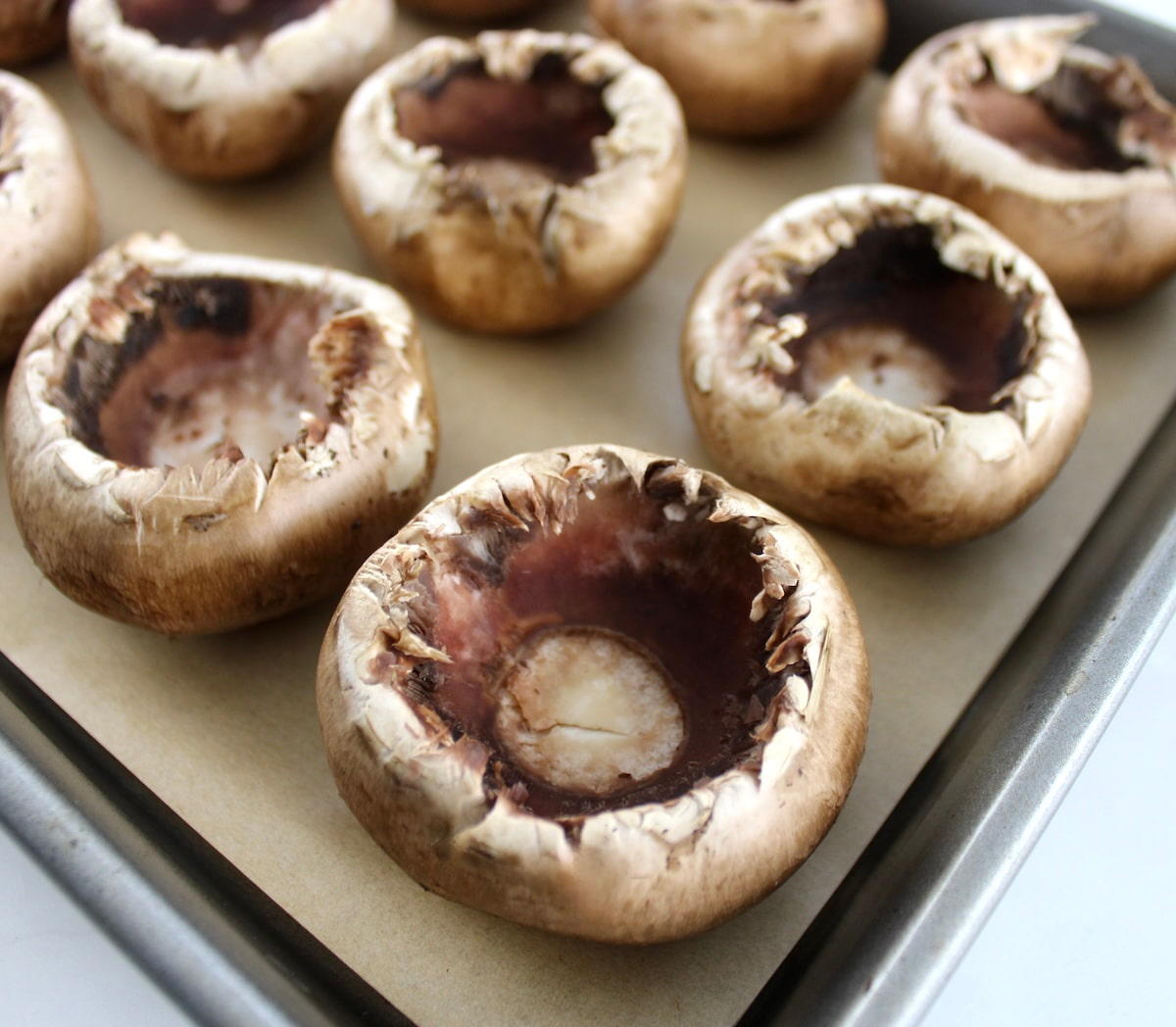 portobello mushrooms on baking sheet with parchment paper