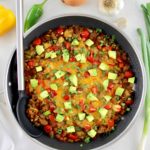 overhead view of Taco Skillet with diced avocado on top with serving spoon on side