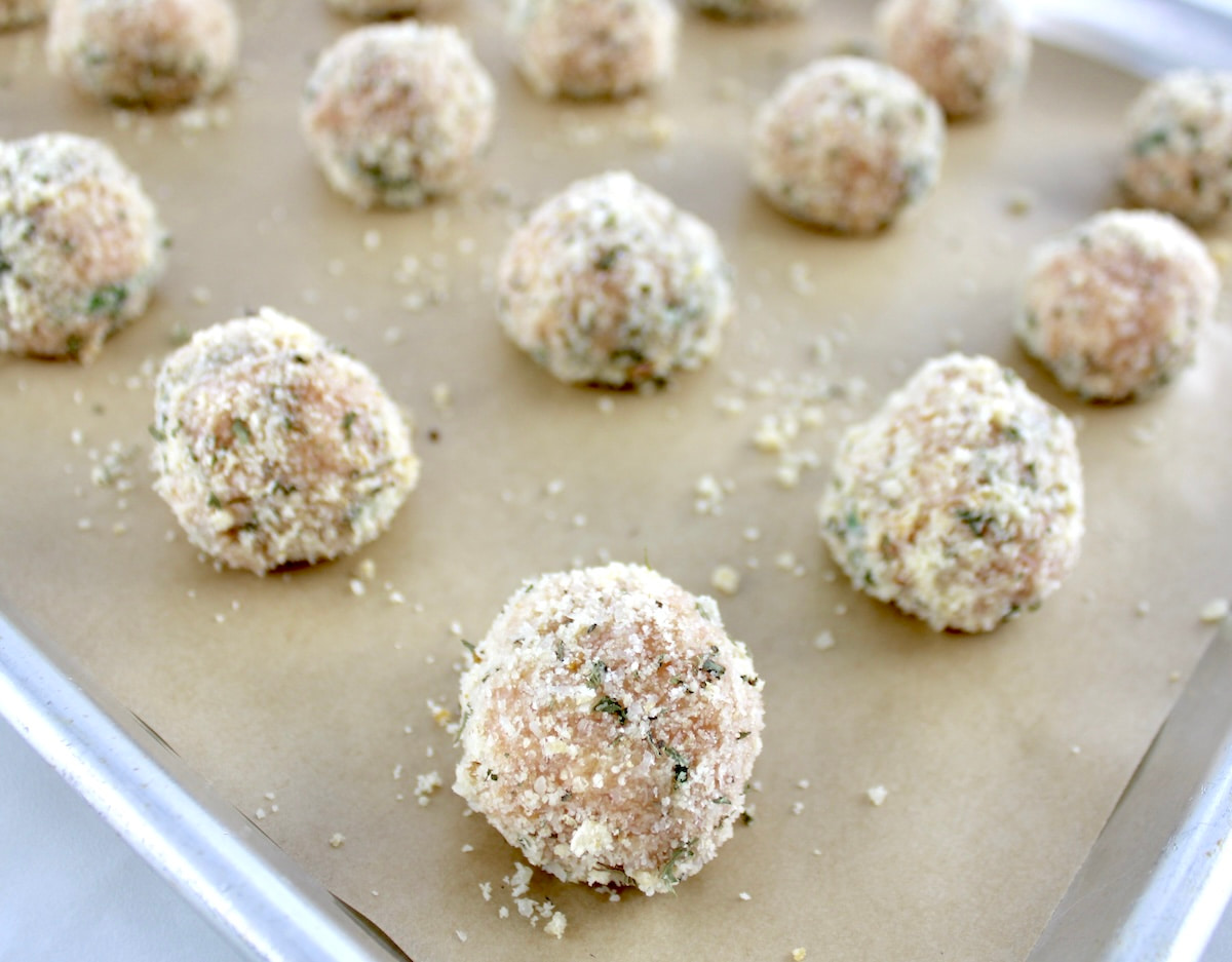 Chicken Parmesan Meatballs raw on baking sheet with parchment paper