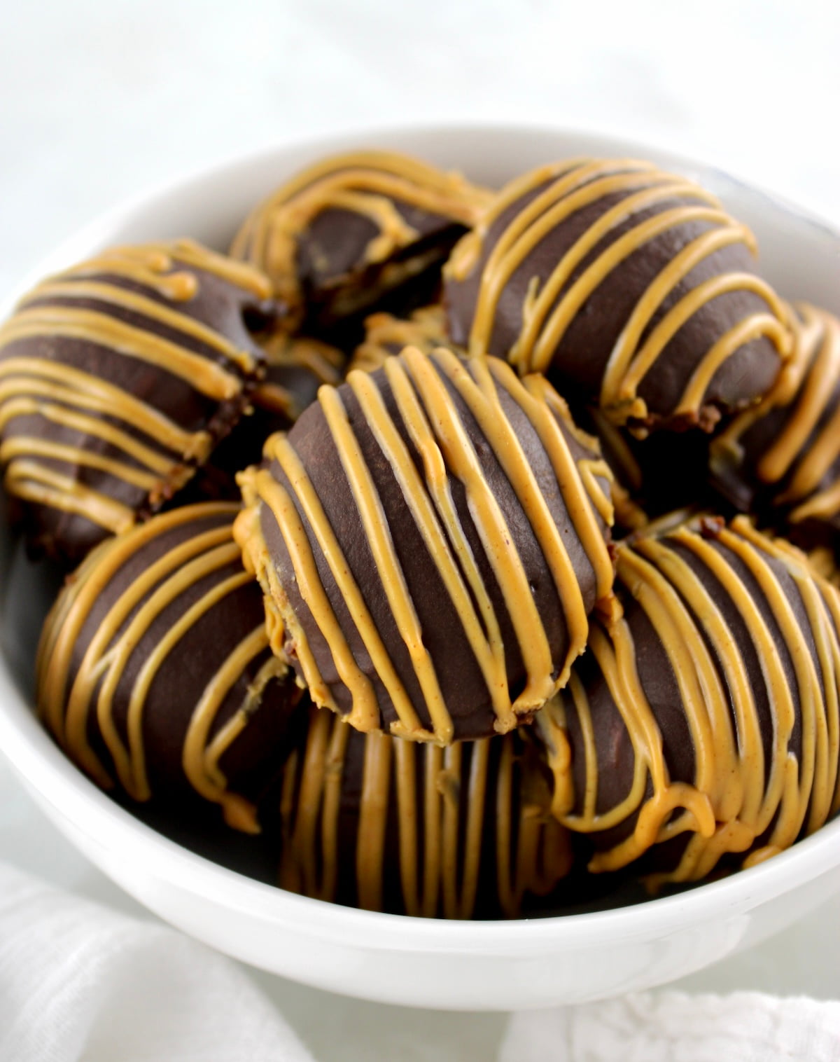 closeup of Chocolate Peanut Butter Truffles in white bowl