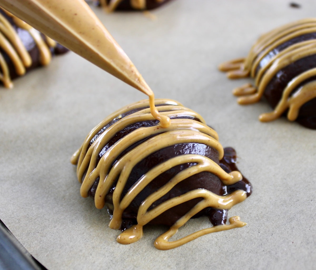 peanut butter being piped over Chocolate Peanut Butter Truffles