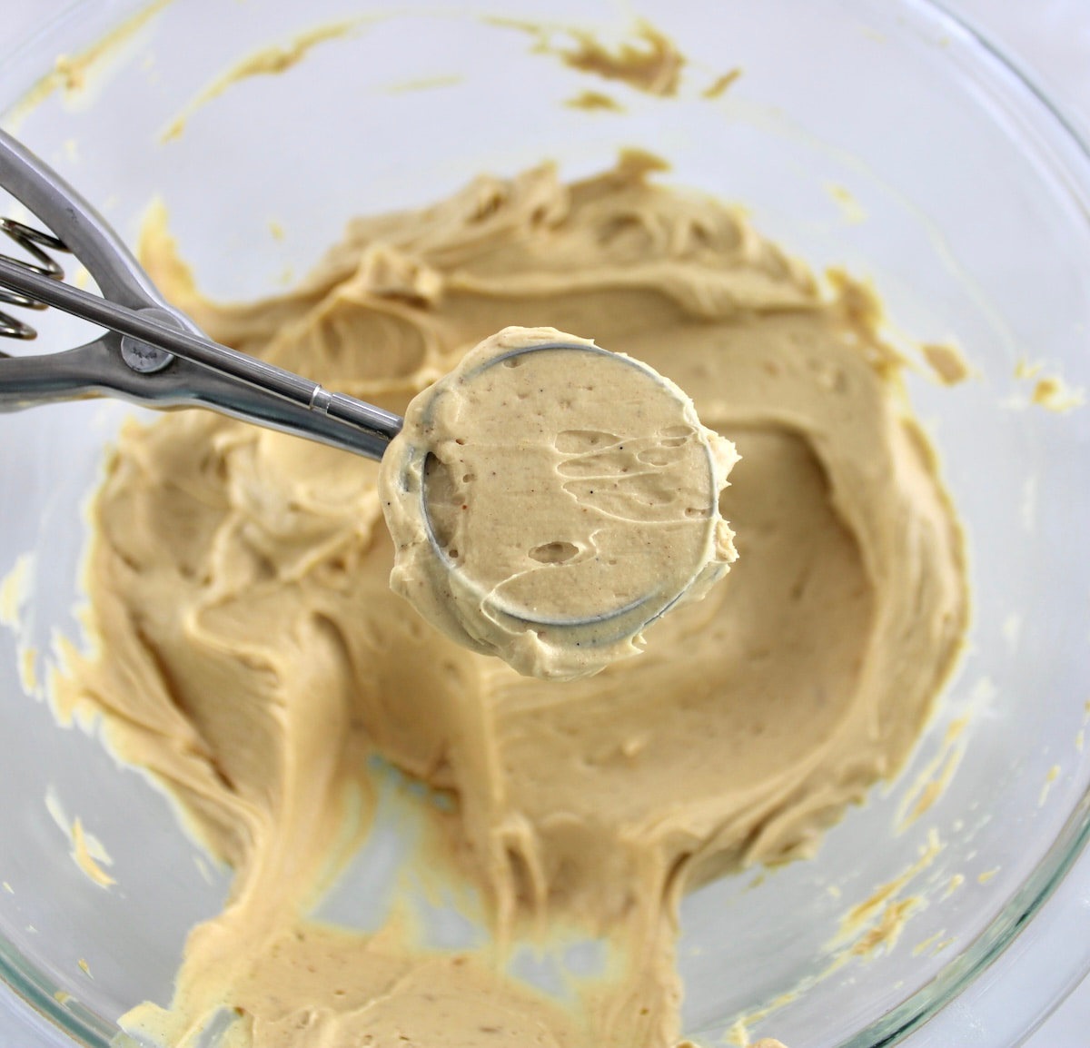 Chocolate Peanut Butter Truffles filling in cookie scoop held over glass bowl