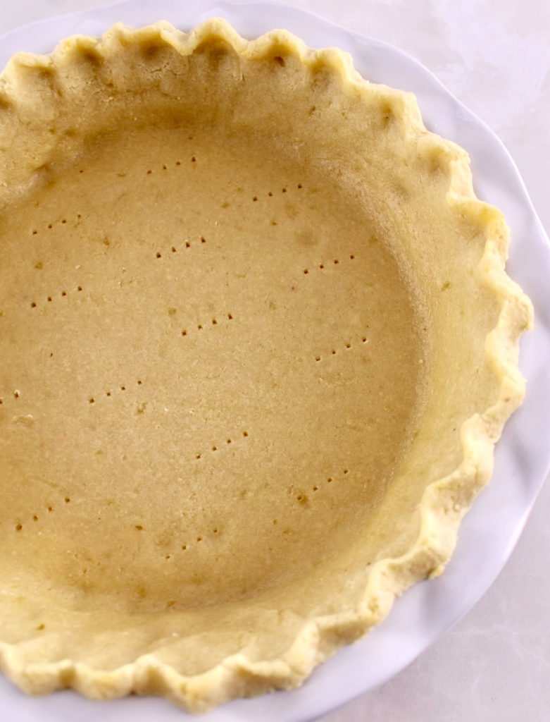 overhead view of Keto Pie Crust in white pie dish
