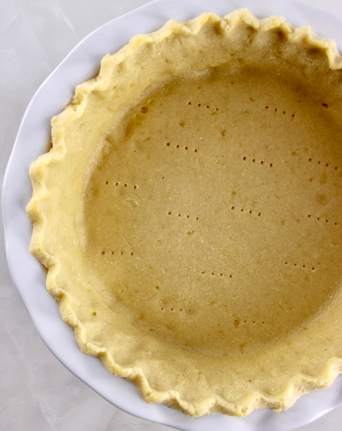 overhead view of Keto Pie Crust in white pie dish