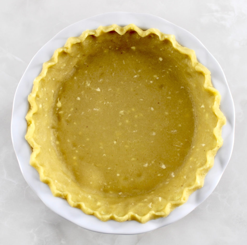 overhead view of Keto Pie Crust unbaked in white pie dish