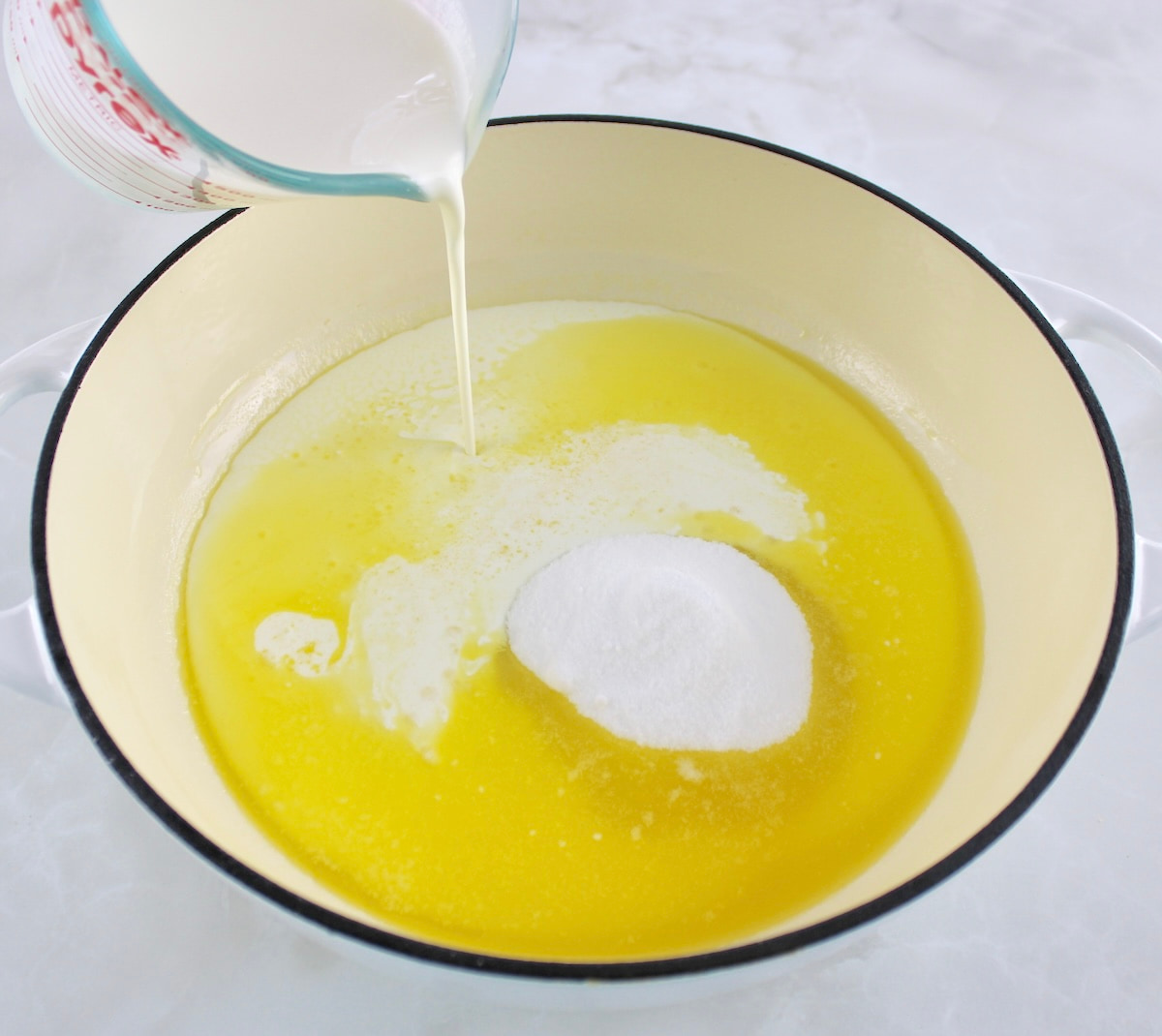 cream being poured into skillet with melted butter and sweetener