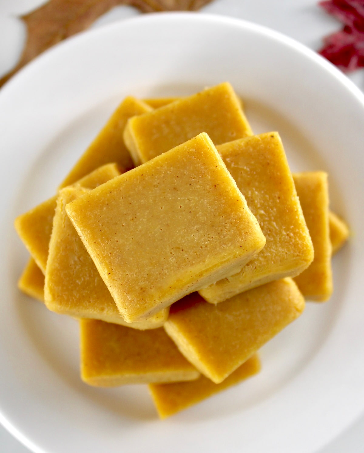 overhead view of Keto Pumpkin Fudge pieces stacked up on white plate