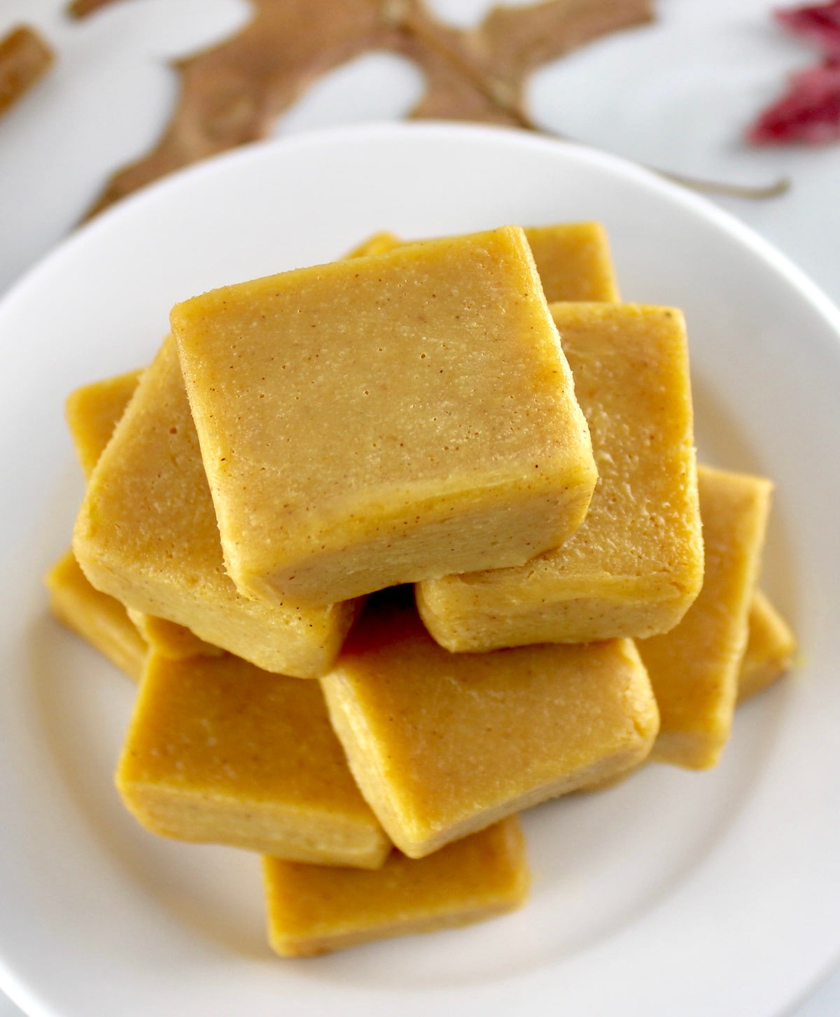 overhead view of Keto Pumpkin Fudge pieces stacked up on white plate