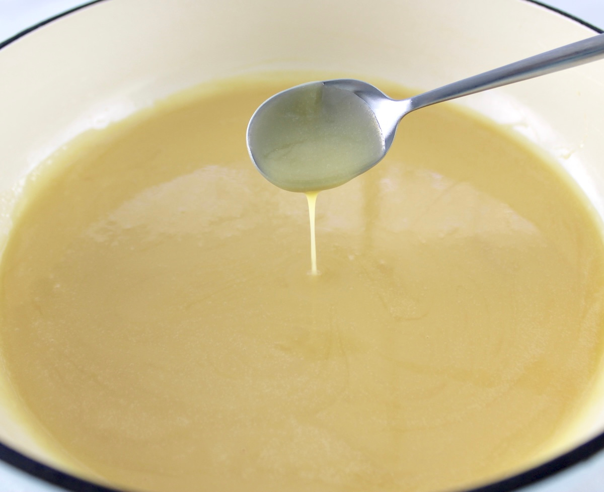 Keto Sweetened Condensed Milk in pot with spoon dripping some
