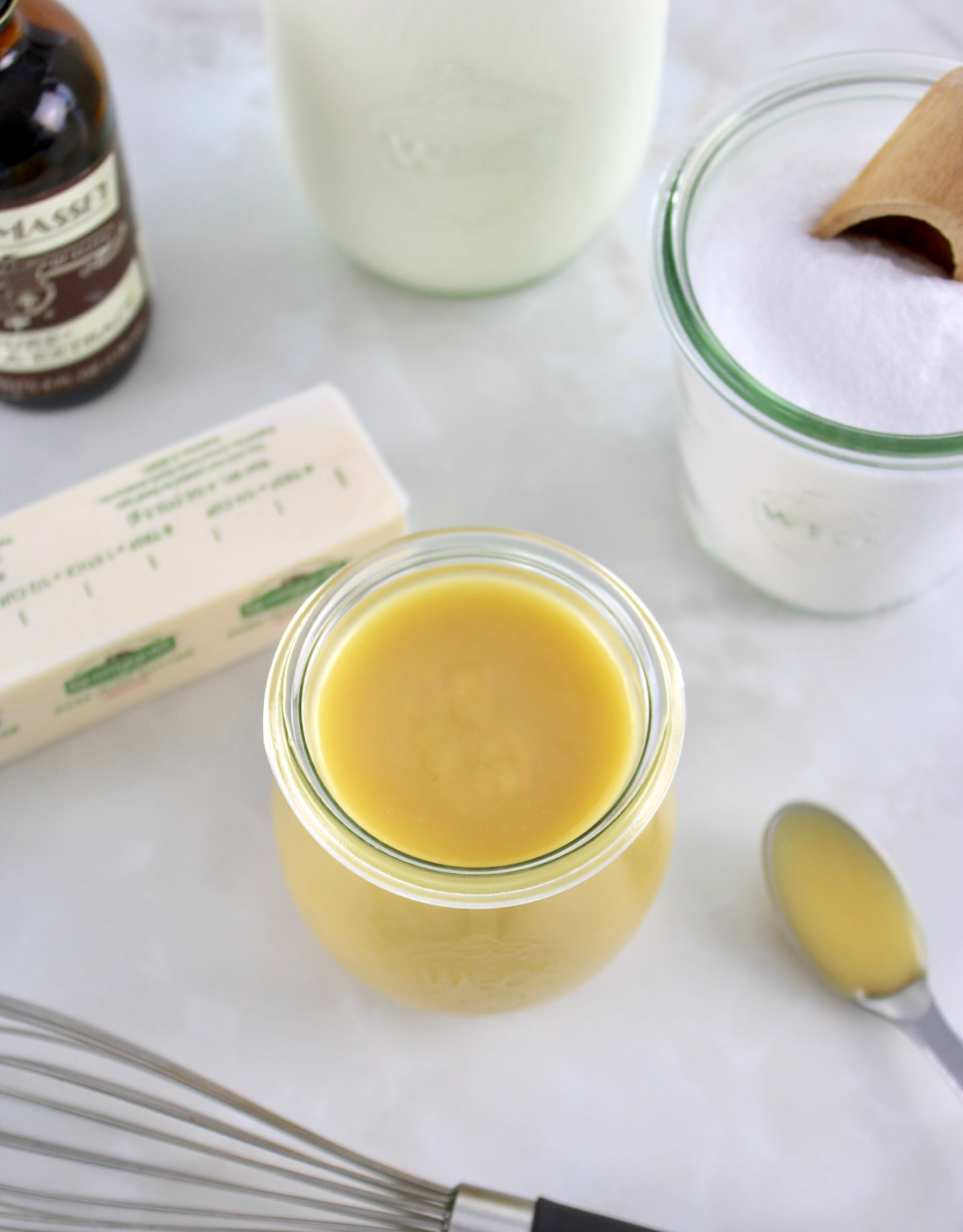 overhead view of Keto Sweetened Condensed Milk in open glass jar with ingredients in back
