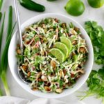 overhead view of Lime Cilantro Broccoli Slaw in white bowl with silver serving spoon on side