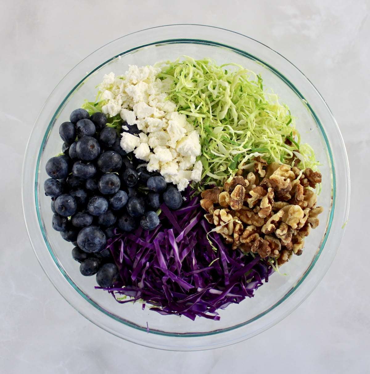 Shaved Brussels Sprouts Salad ingredients in glass bowl in sections unmixed