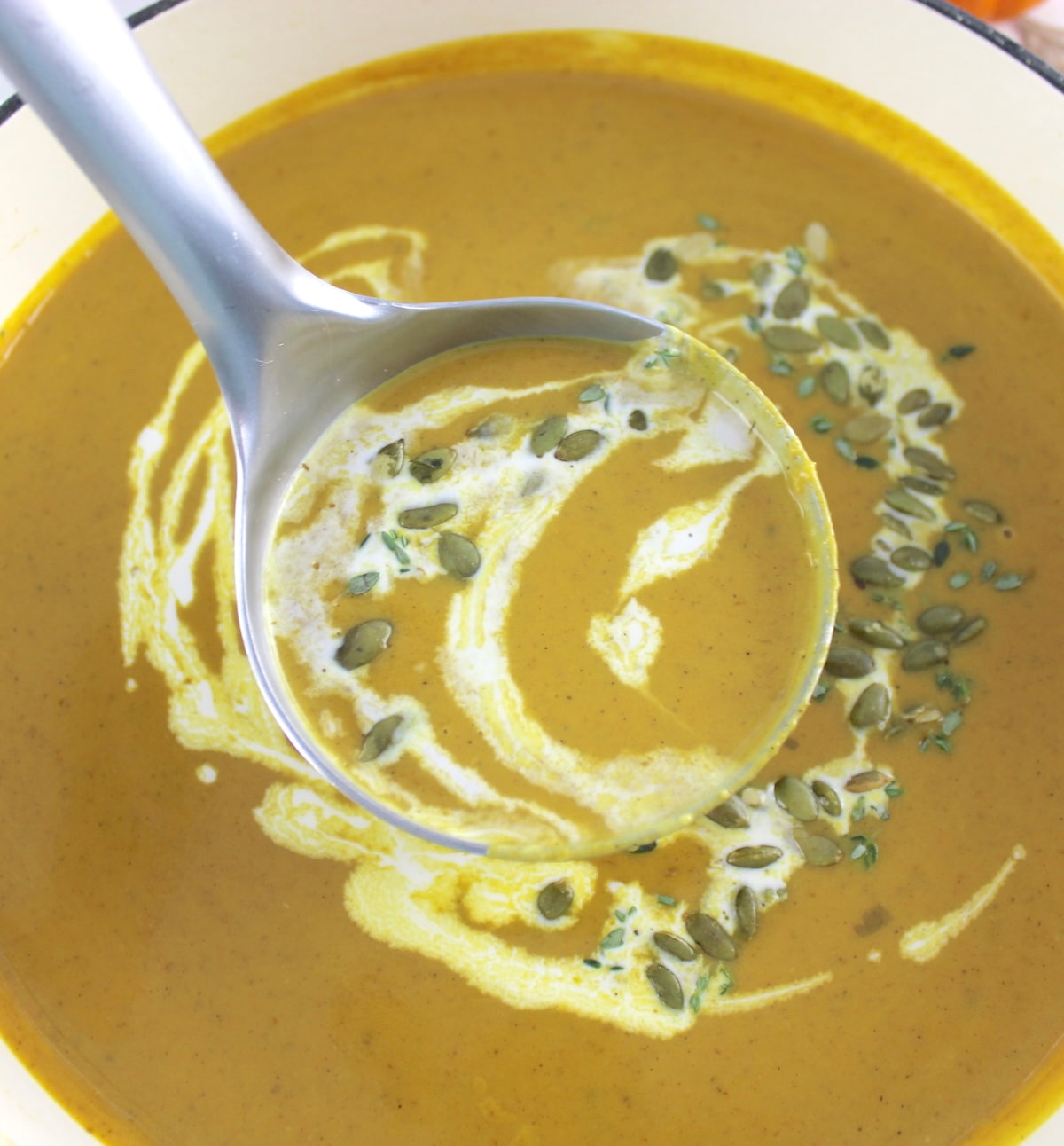 Easy Pumpkin Soup in ladle held over pot