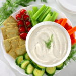 Easy Veggie Dip in white bowl with veggies and crackers around