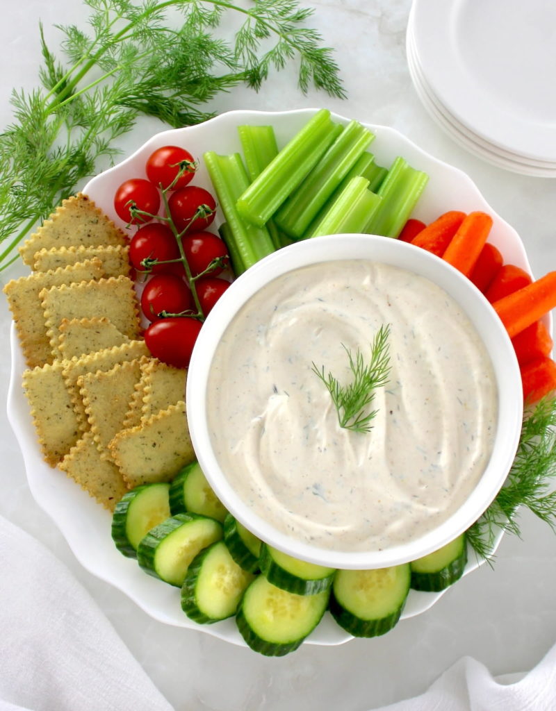 Easy Veggie Dip in white bowl with veggies and crackers around