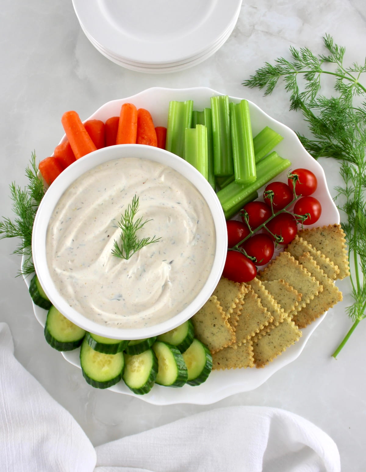 Easy Veggie Dip in white bowl with veggies and crackers around