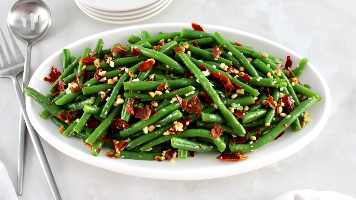 overhead view of Green Beans with Crispy Prosciutto on white oval platter