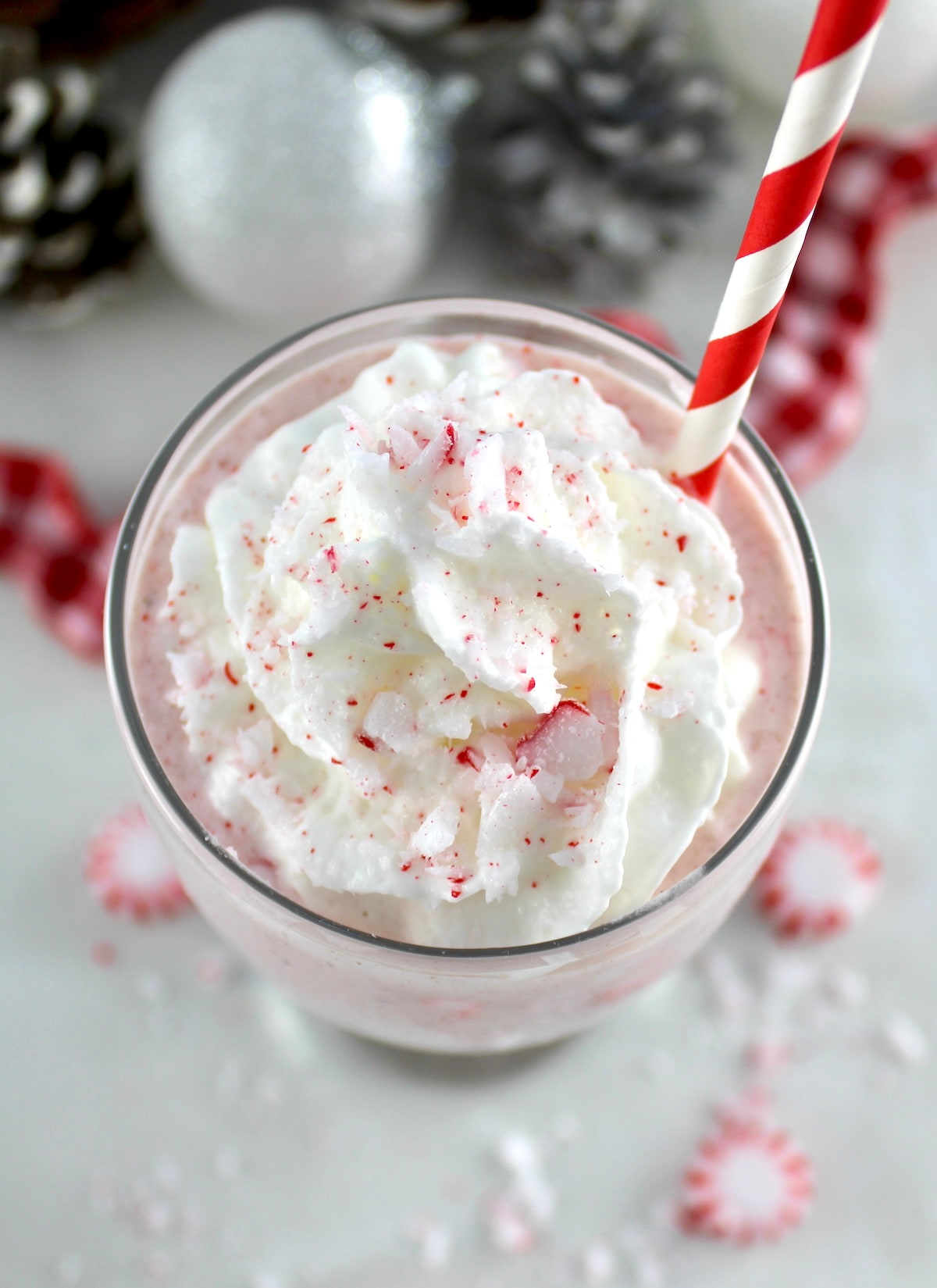 overhead view of Keto Peppermint Chip Milkshake with red straw and whip cream on top