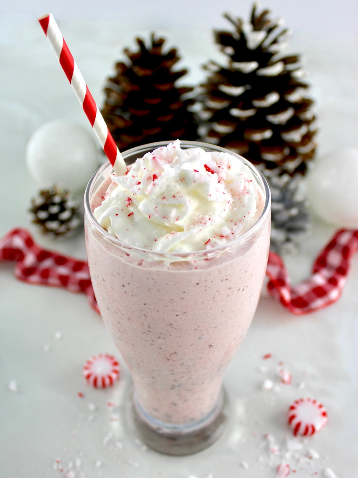 Keto Peppermint Chip Milkshake in glass with red straw and whip cream