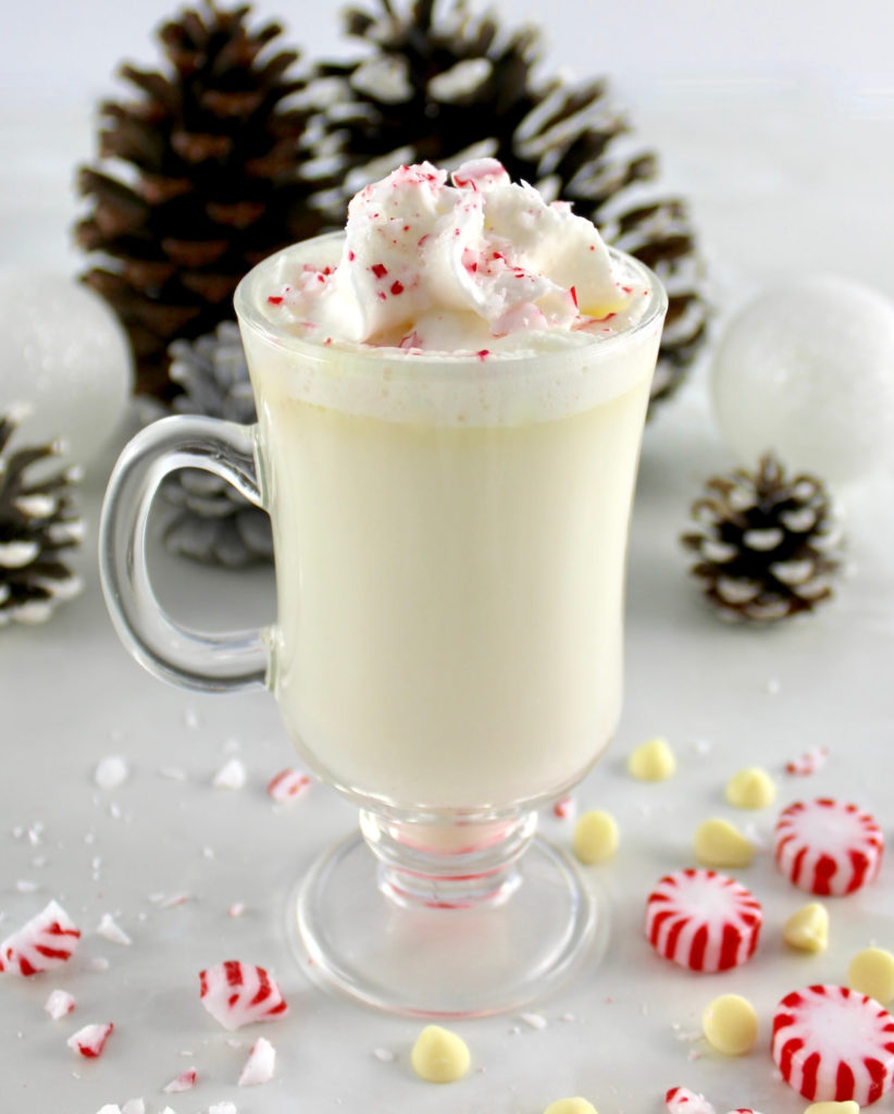 Peppermint White Hot Chocolate in glass with whip cream and crush peppermints on top