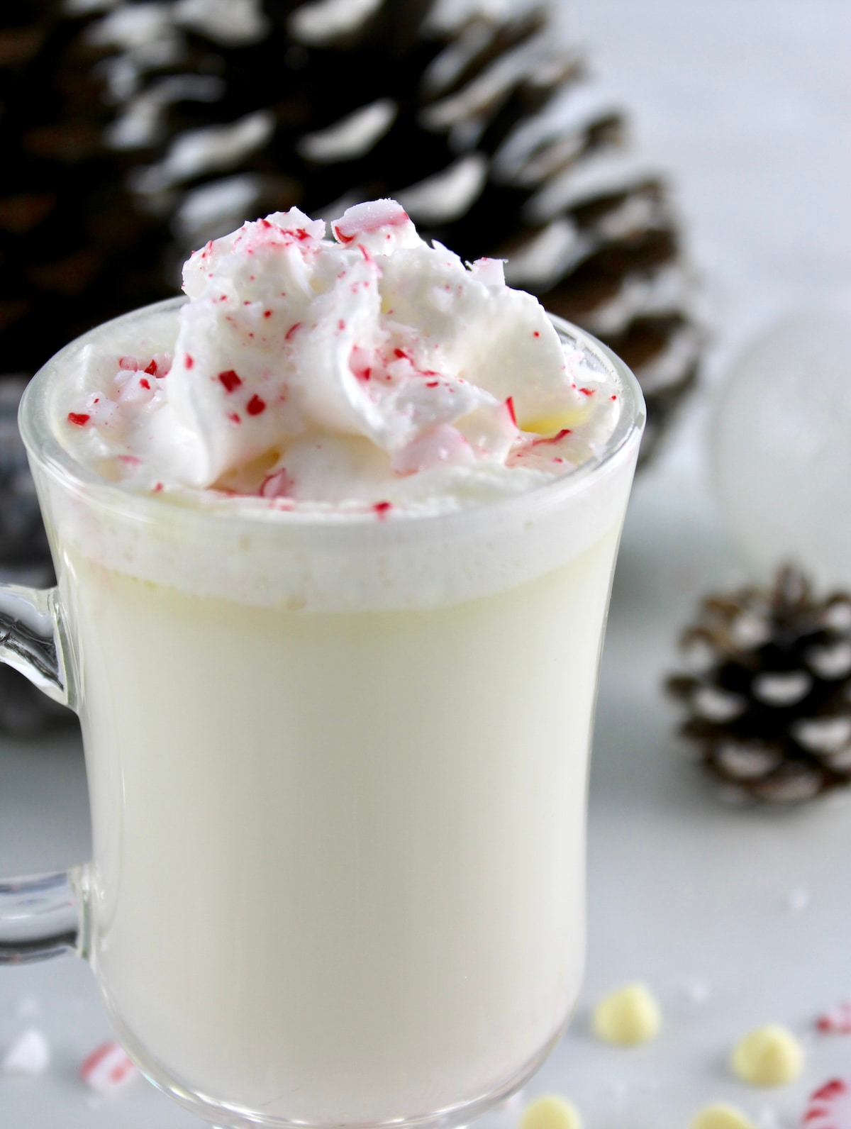 closeup side view of Peppermint White Hot Chocolate in glass with whip cream and crushed peppermints on top