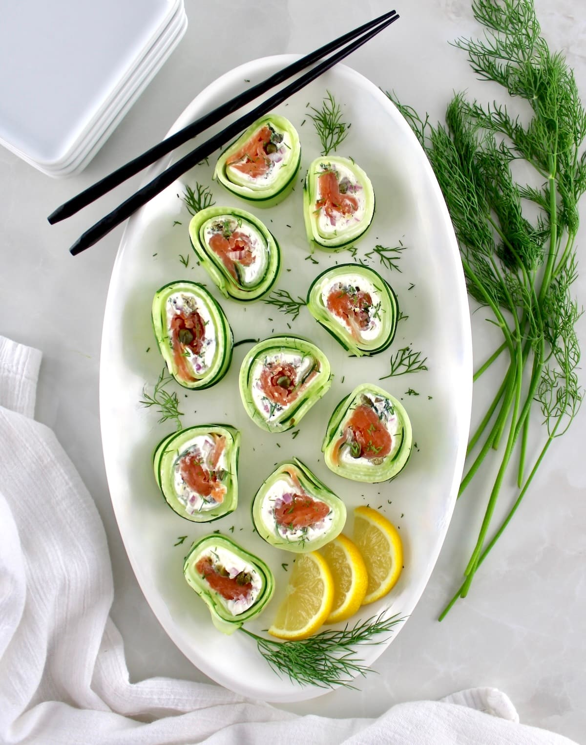 overhead view of Salmon Cucumber Rolls on white oval platter