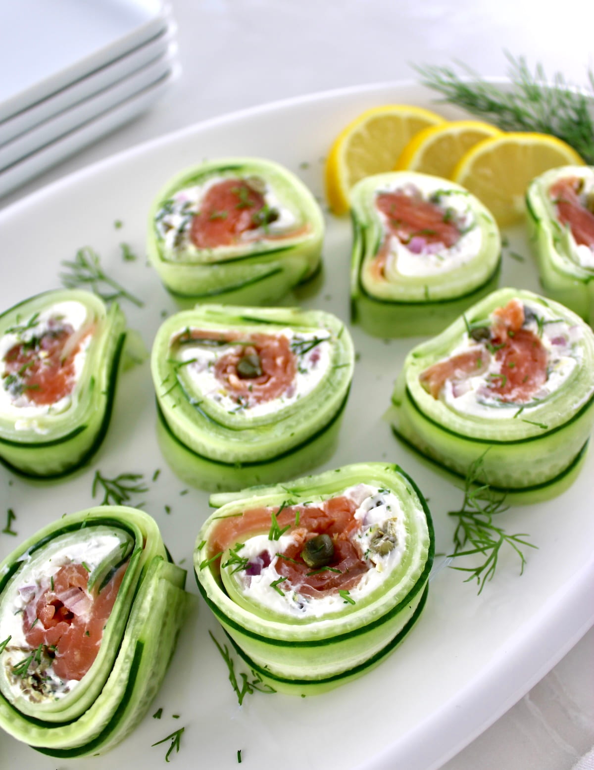 holding up Salmon Cucumber Roll with black chopsticks