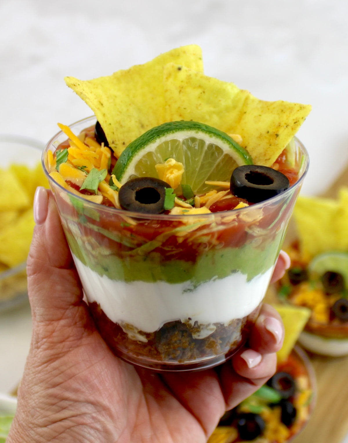 holding up Taco Dip Cup in hand