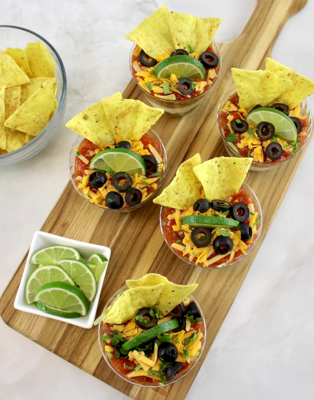 overhead view of Taco Dip Cups on wooden cutting board