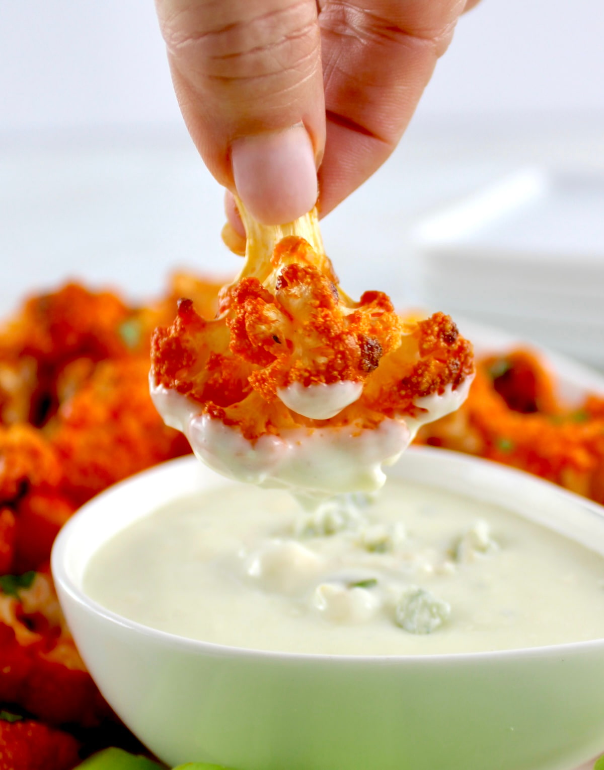 Air Fryer Buffalo Cauliflower being dipped into blue cheese