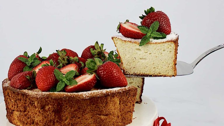 slice of angel food cake being taken off cake stand