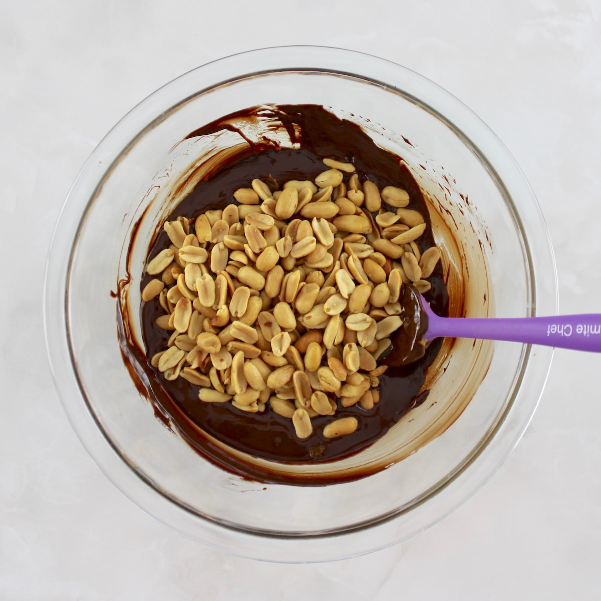 peanuts in glass bowl with melted chocolate