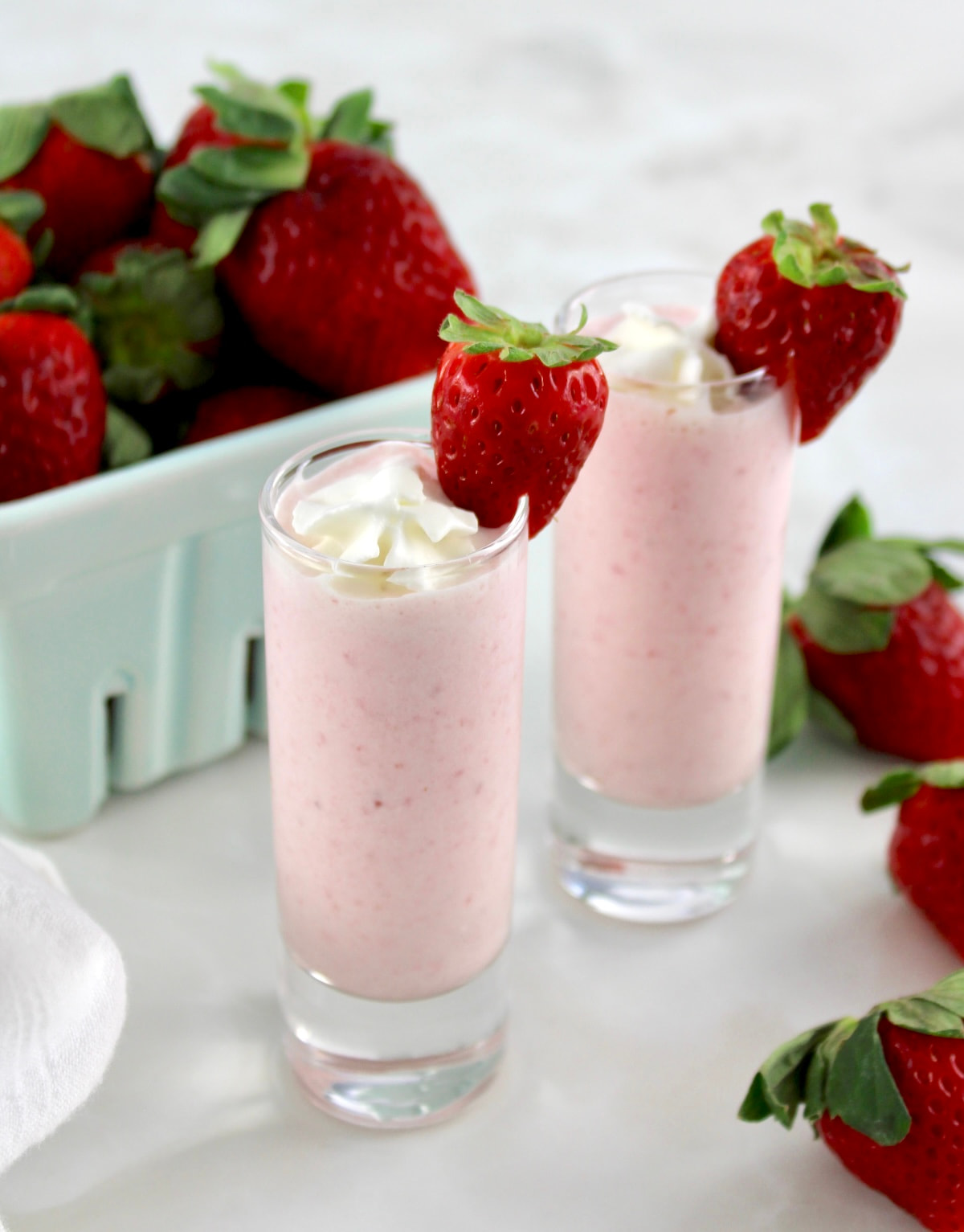 2 shot glasses with Keto Strawberry Milkshake and strawberries on side
