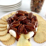 Maple Pecan Baked Brie on white plate with round crackers around