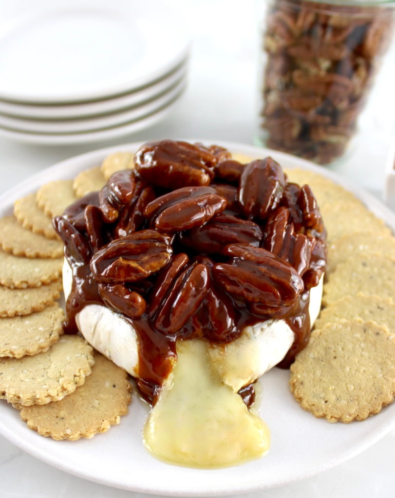 Maple Pecan Baked Brie on white plate with round crackers around