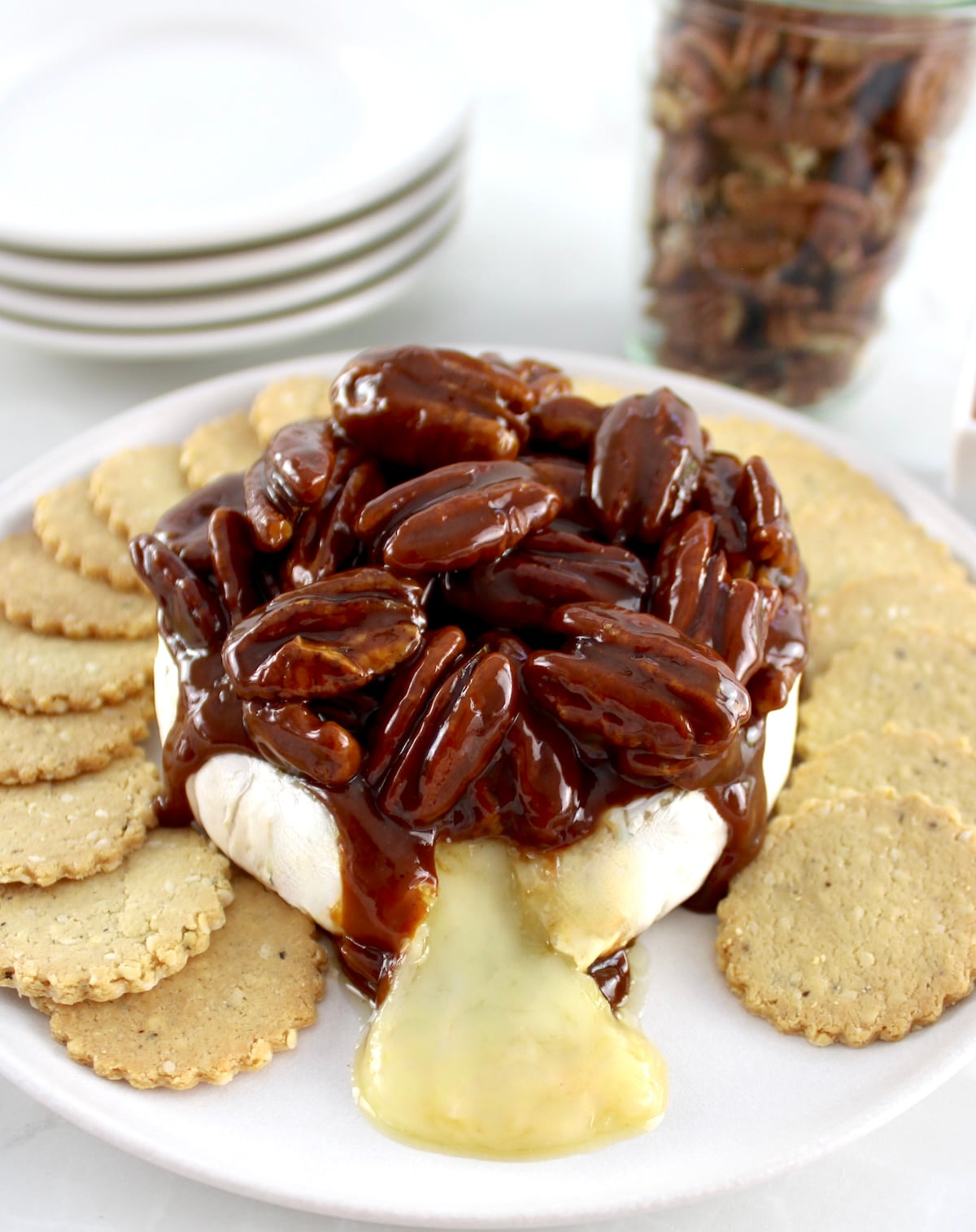 Maple Pecan Baked Brie on white plate with round crackers around