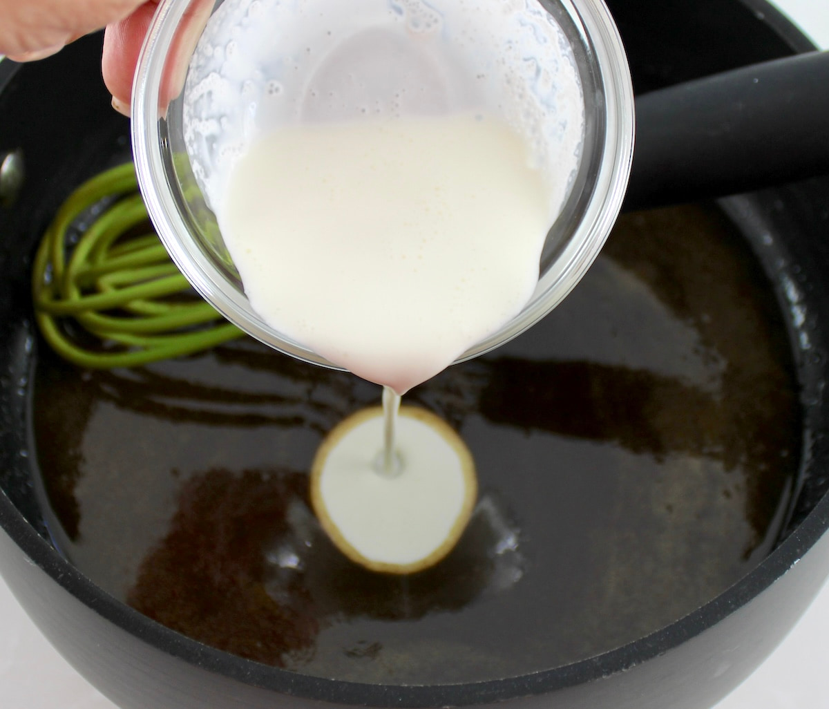cream being poured into skillet with caramel sauce