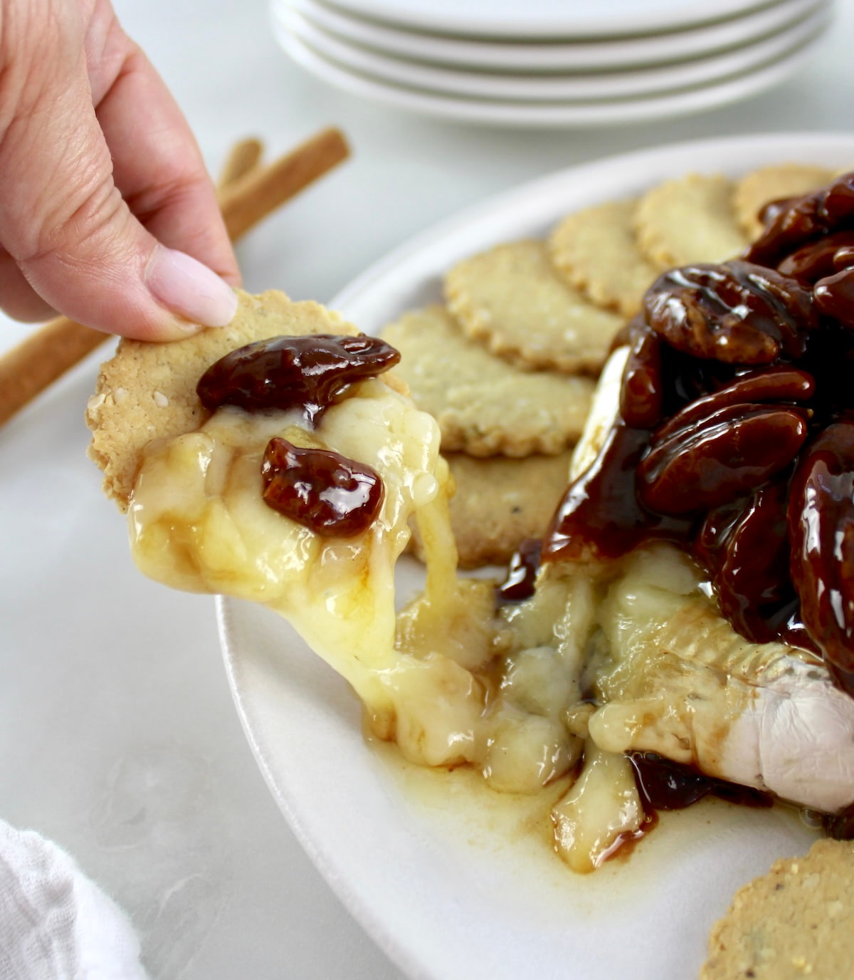 cracker scooping up Maple Pecan Baked Brie