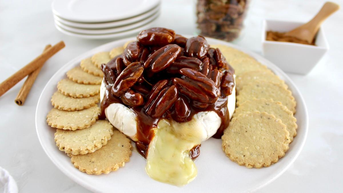 Maple Pecan Baked Brie on white plate with round crackers around