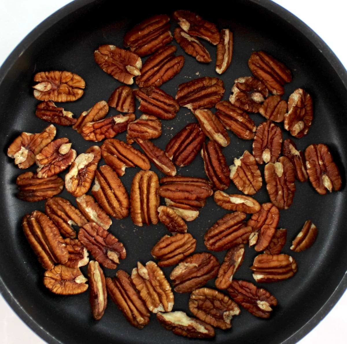 pecan halves toasting in skillet