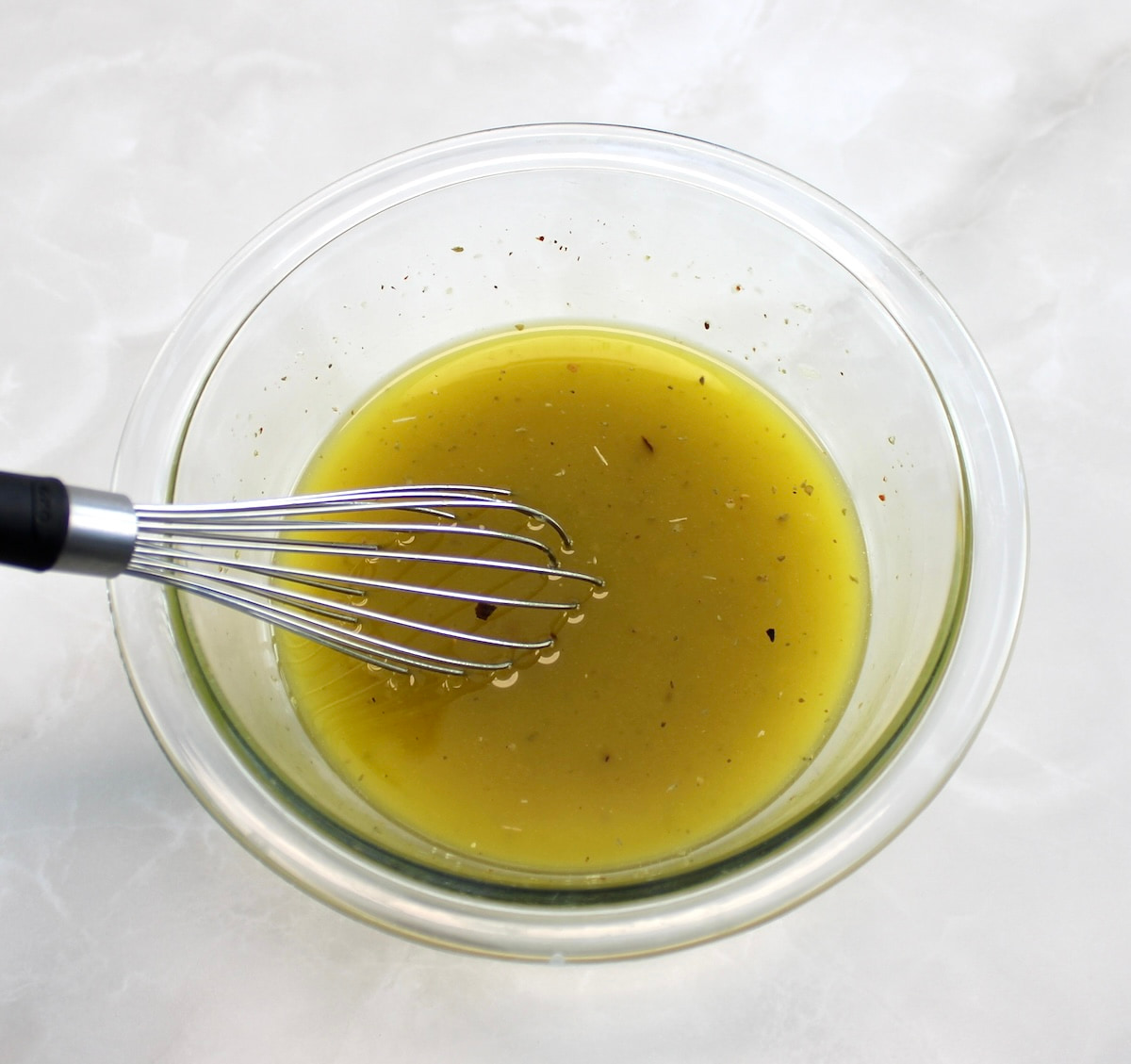 Marinated Mozzarella Balls (Ciliegine) in glass bowl with whisk