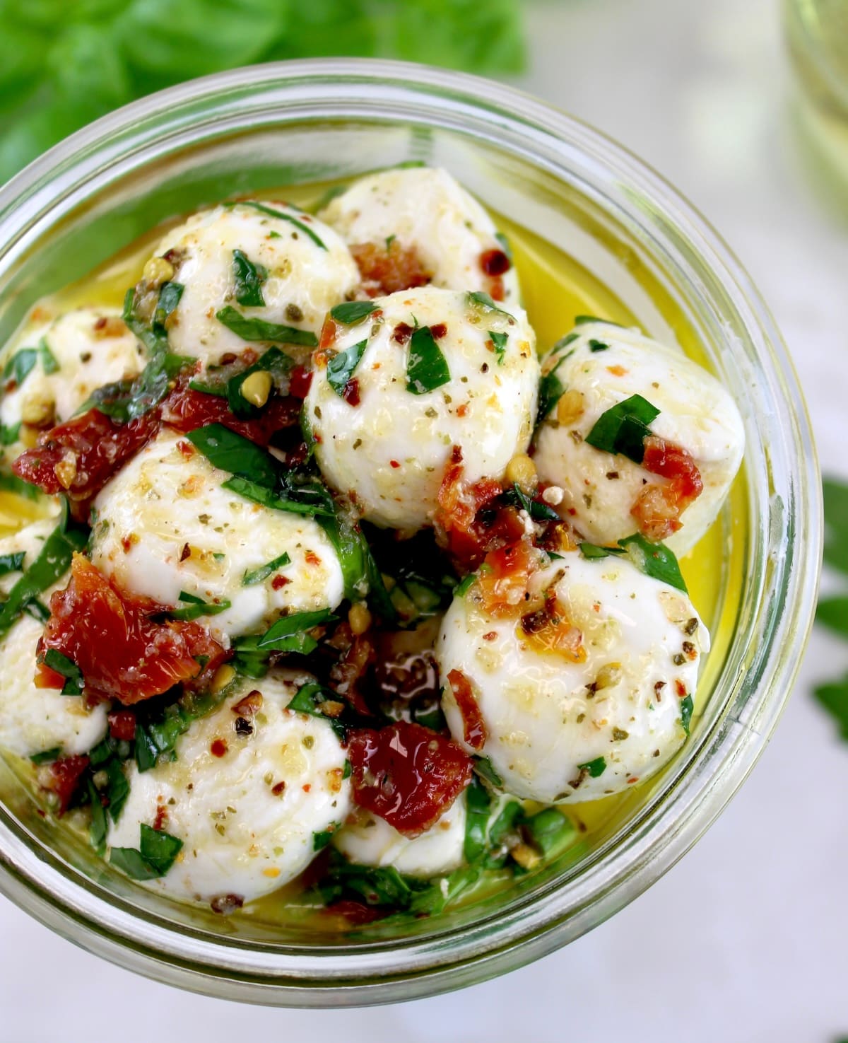 overhead view of Marinated Mozzarella Balls (Ciliegine) in open glass jar