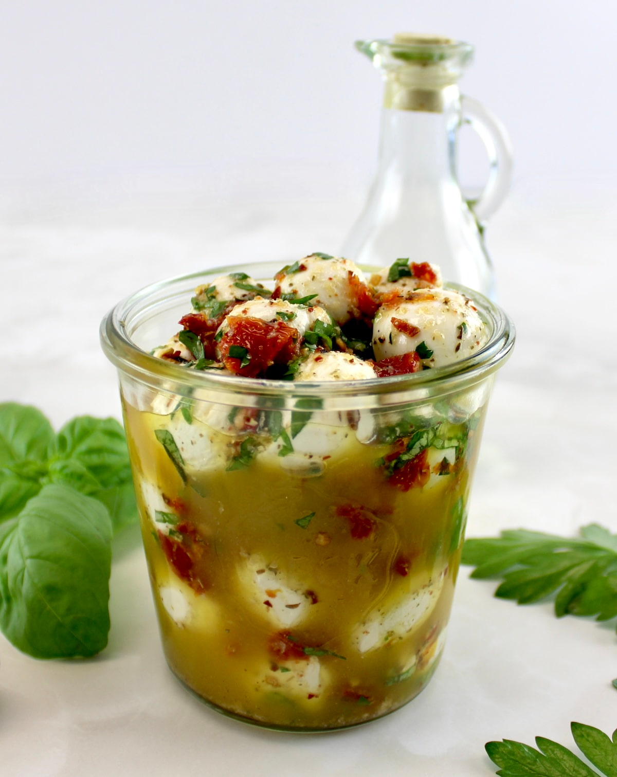 closeup side view of Marinated Mozzarella Balls (Ciliegine) in open glass jar