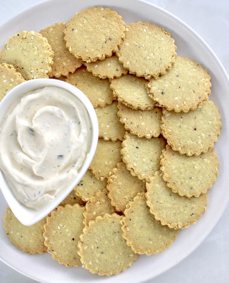 Sesame Almond Flour Crackers on plate in concentric circles around a dip in white bowl