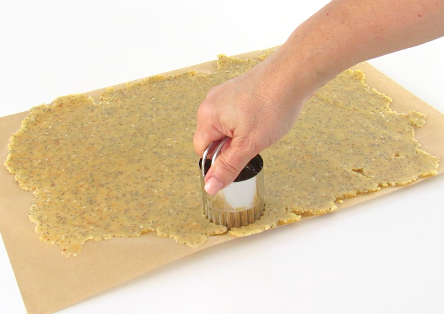 stamping out Sesame Almond Flour Cracker with biscuit cutter
