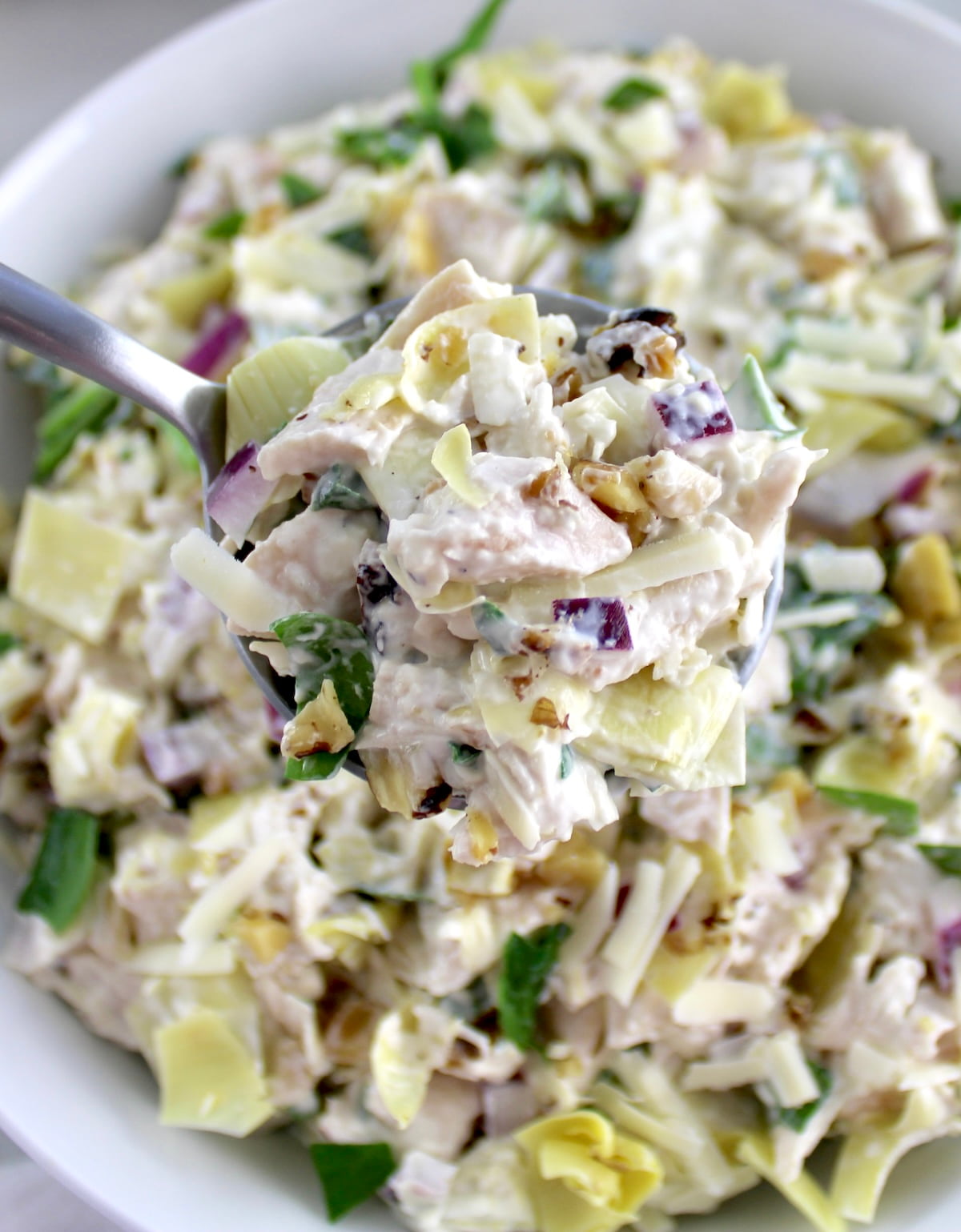 spoon holding up Spinach Artichoke Chicken Salad