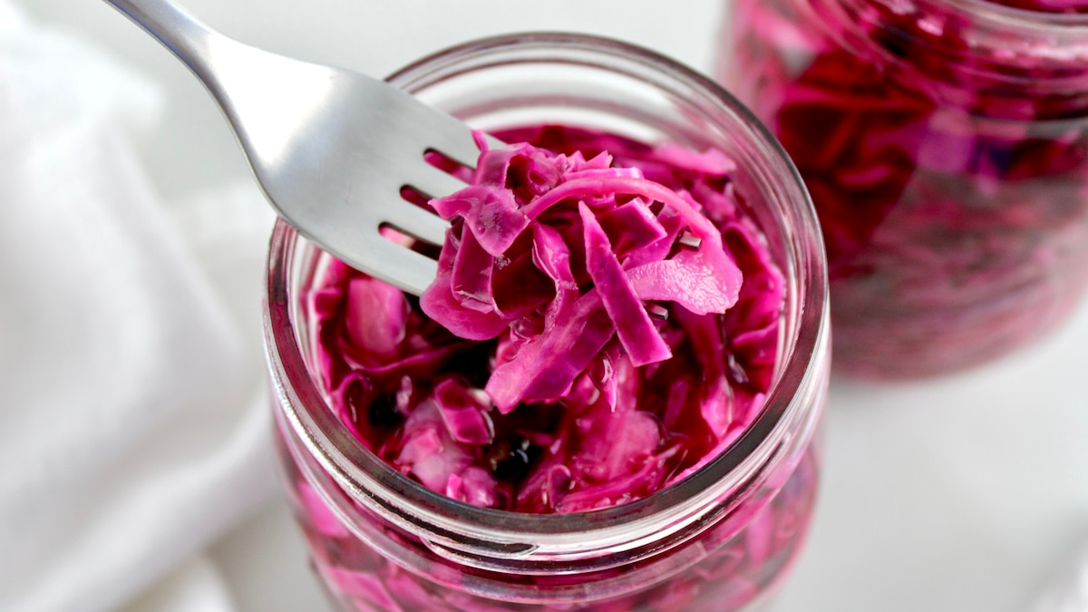 Easy Pickled Red Cabbage in open glass jar with fork holding up some