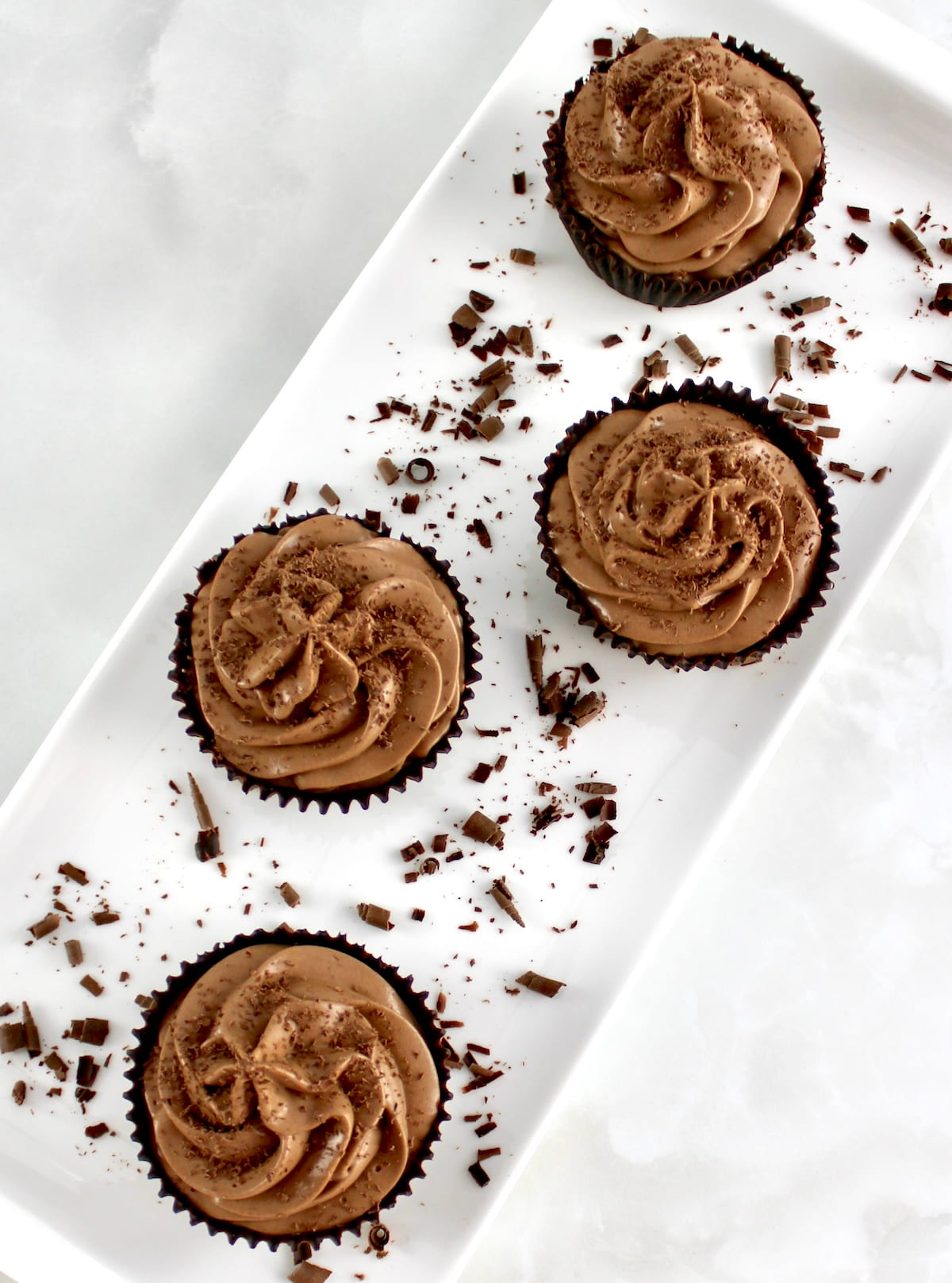 overhead view of 5 Espresso Chocolate Mousse Cups on white platter with shaved chocolate around