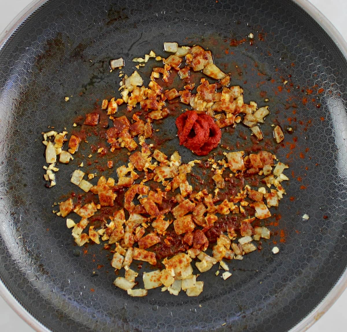 diced onions, garlic, tomato paste and smoked paprika in skillet