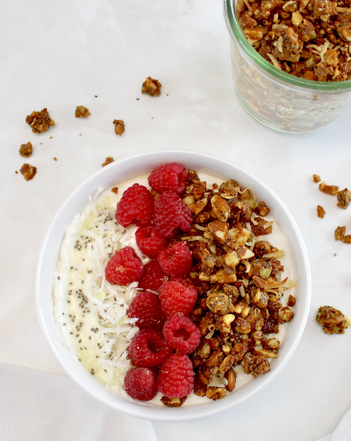 Keto Granola in yogurt bowl with raspberries down the middle